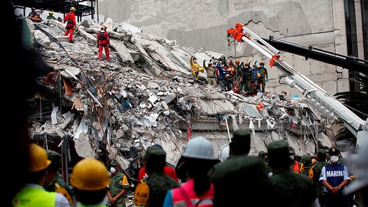 / Equipos de rescate guardan silencio después de recuperar un cadáver de un edificio derrumbado en la Ciudad de México. / Carlos Jasso / Reuters