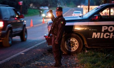 / Un oficial de policía realiza inspecciones luego de que 13 personas murieran en una batalla entre pandillas rivales en Michoacán. Alan Ortega / Reuters