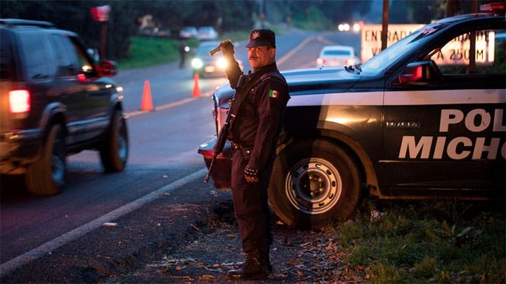 / Un oficial de policía realiza inspecciones luego de que 13 personas murieran en una batalla entre pandillas rivales en Michoacán. Alan Ortega / Reuters