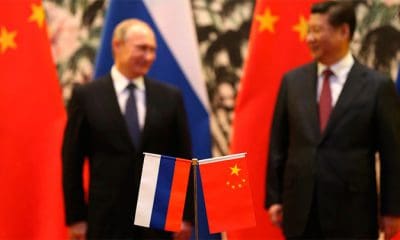 / Banderas rusas y chinas se ven sobre la mesa con el presidente ruso Vladimir Putin y su homólogo chino Xi Jinping al fondo durante una ceremonia en Pekín, el 9 de noviembre de 2014. How Hwee Yong / Reuters