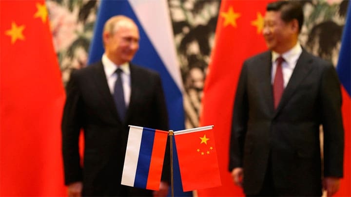 / Banderas rusas y chinas se ven sobre la mesa con el presidente ruso Vladimir Putin y su homólogo chino Xi Jinping al fondo durante una ceremonia en Pekín, el 9 de noviembre de 2014. How Hwee Yong / Reuters