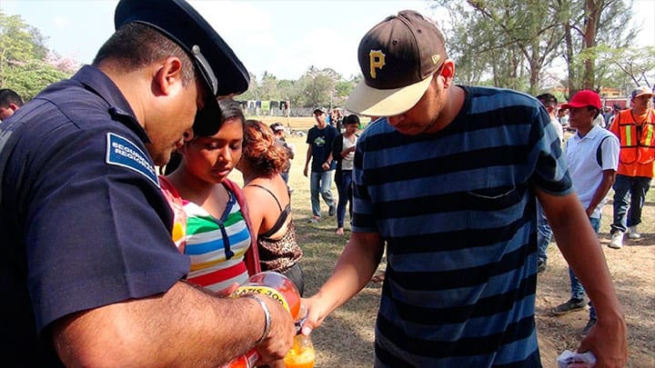 / Un policía sirve refresco a un migrante centroamericano que participa en una caravana que se dirige a Estados Unidos en Matias Romero, Oaxaca, el 2 de abril de 2018. Jose de Jesus Cortes / Reuters